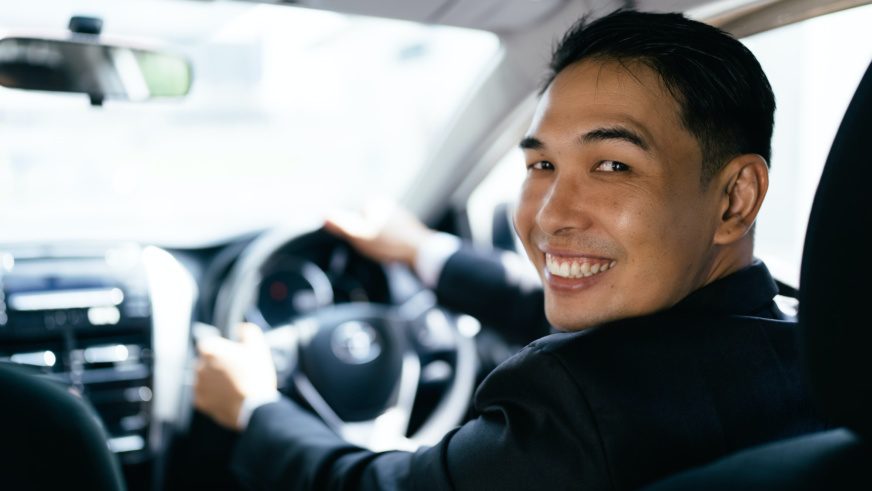 Asian businessman driving car and smile, car insurance concept.