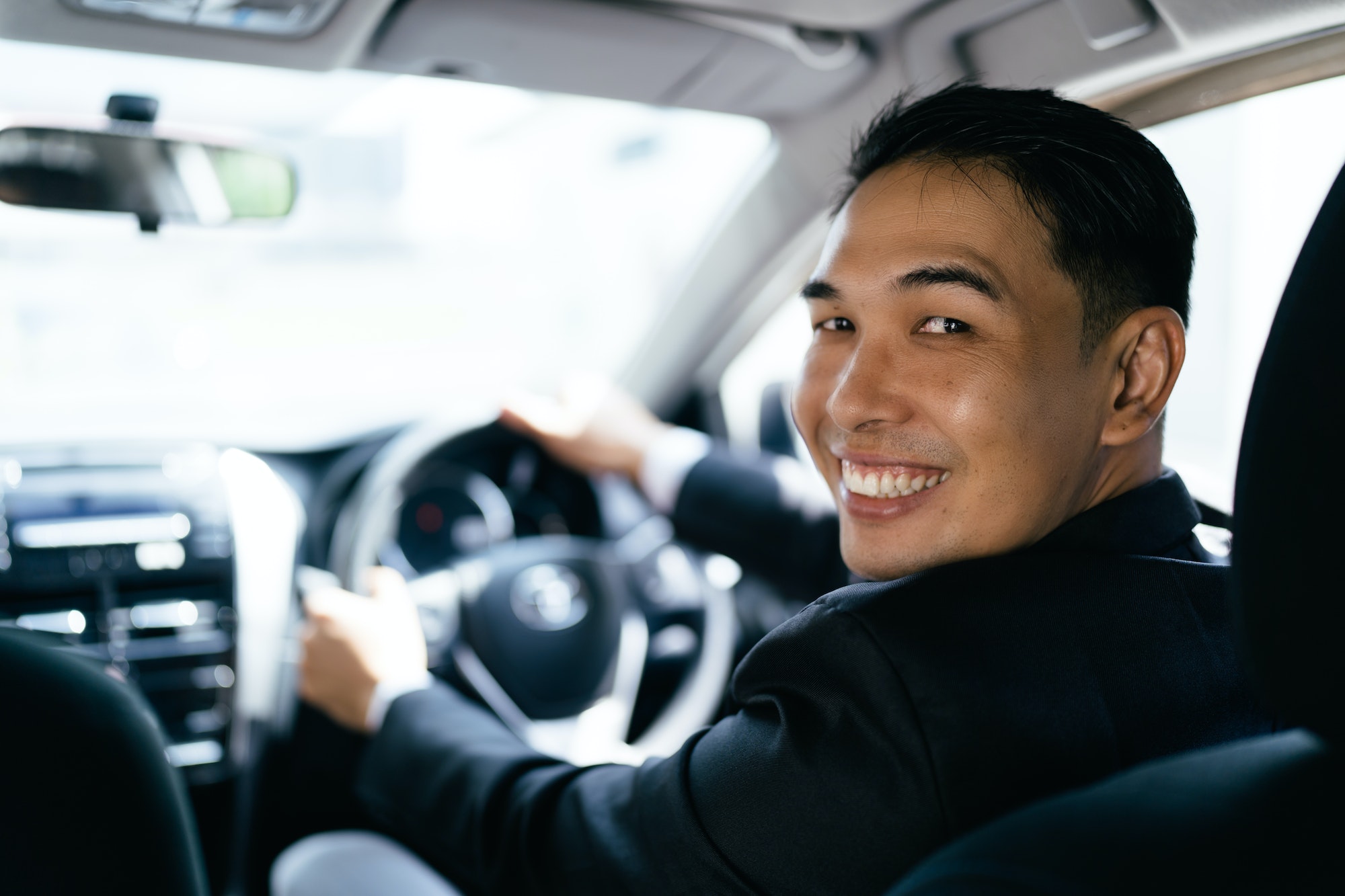 Asian businessman driving car and smile, car insurance concept.