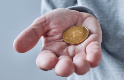 Hand offering Ethereum cryptocurrency coin