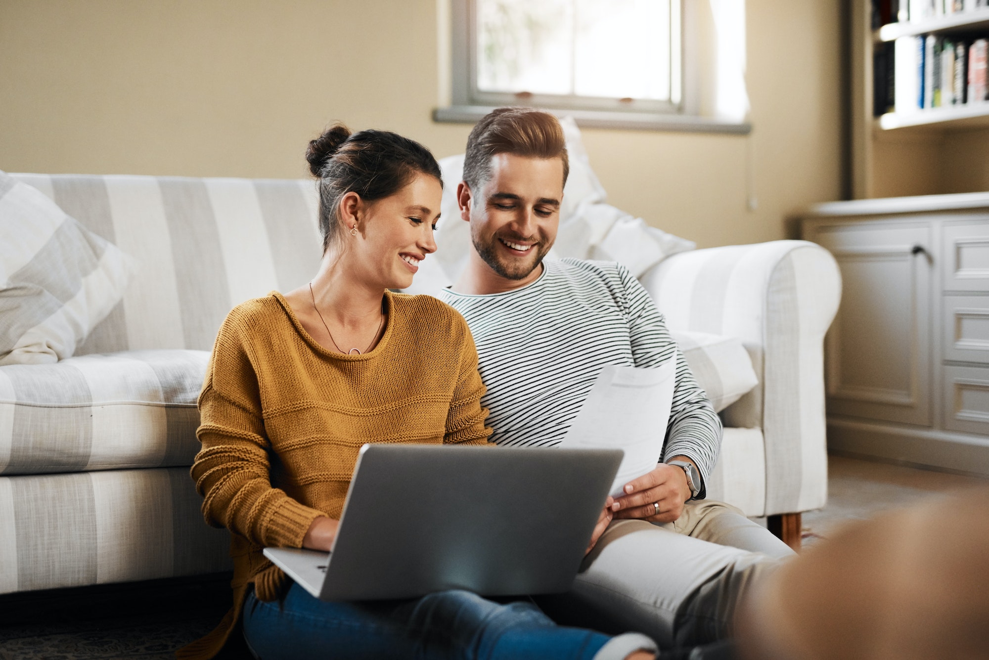 Lets check our credit score. Shot of a young couple using a laptop while relaxing at home.