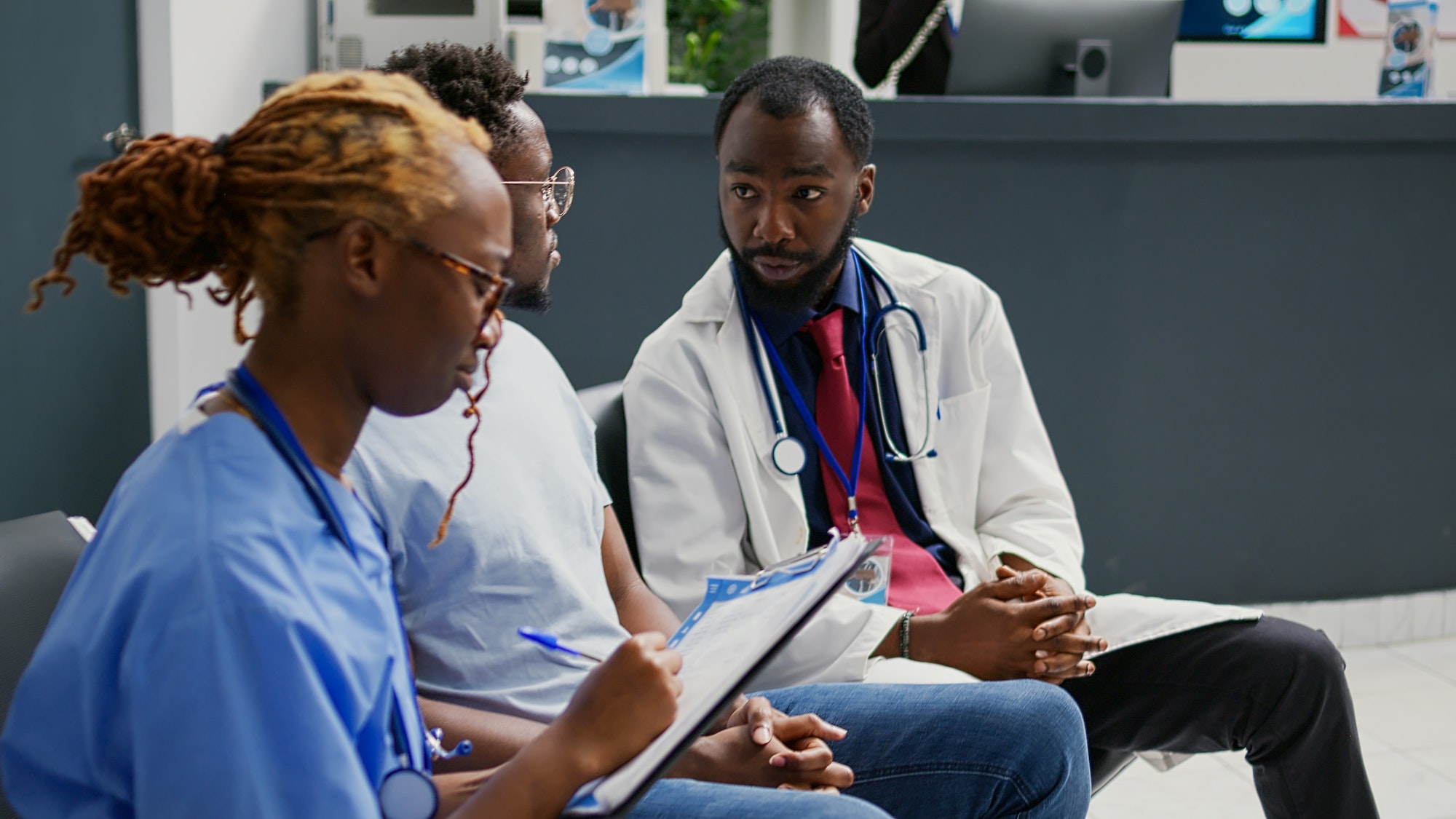 Team of medical workers consulting young man in clinic reception lobby