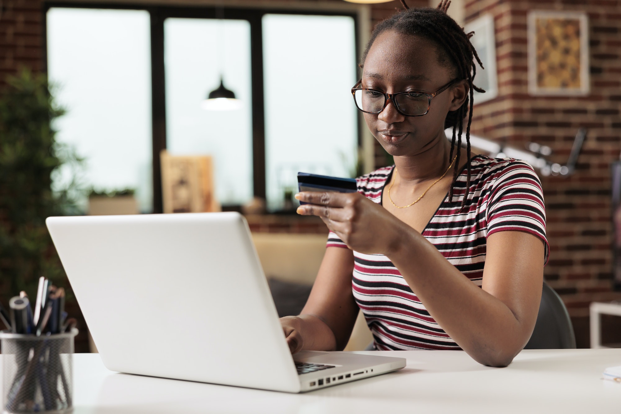 Woman holding credit card, making payment in online store