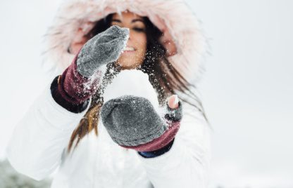 Young woman playing with snowball